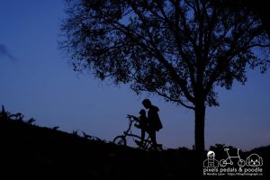 A cycling photographer with his dog in the park during blue hour