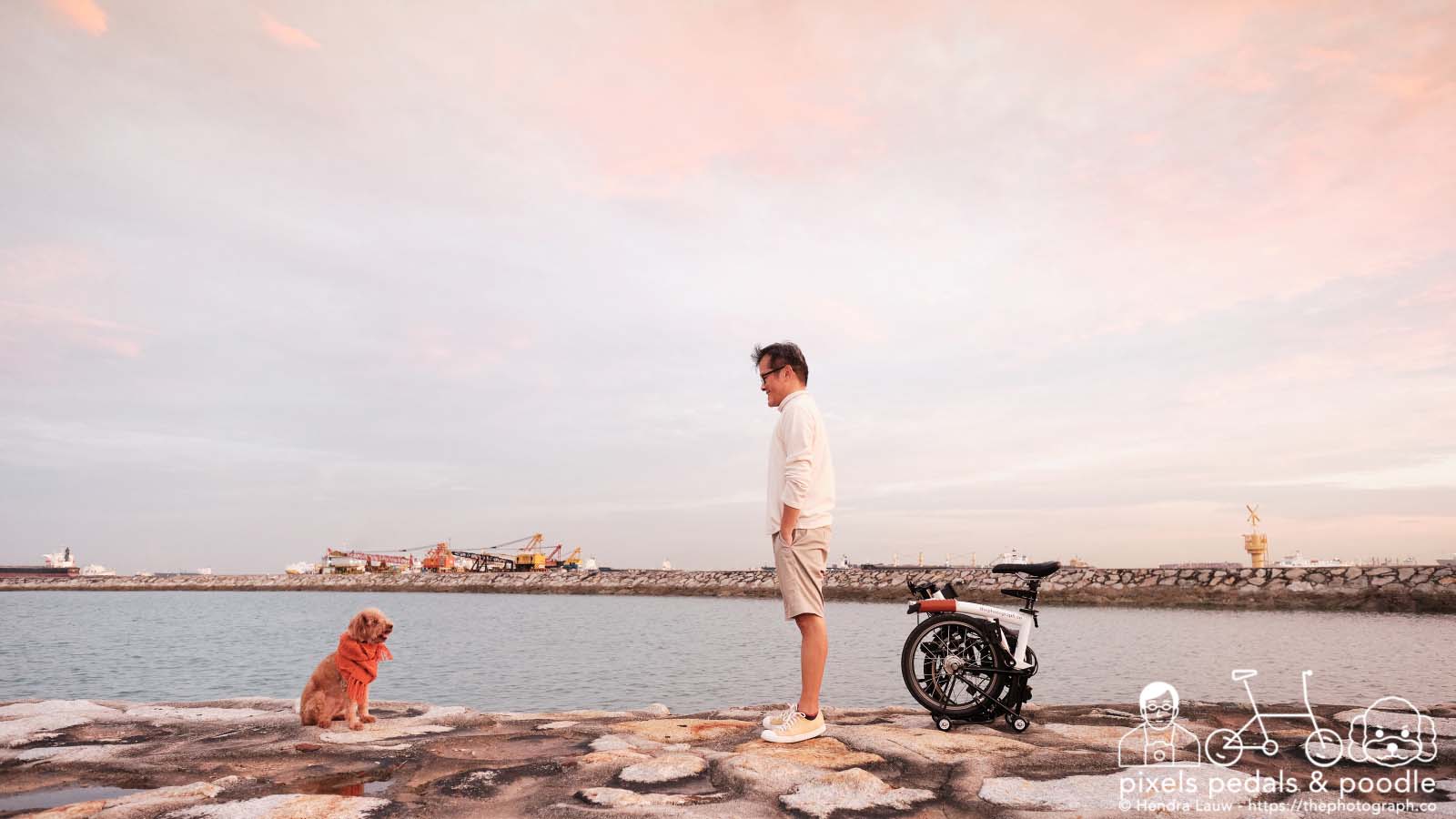 A man his dog and bike during sunset at Marina East Breakwater